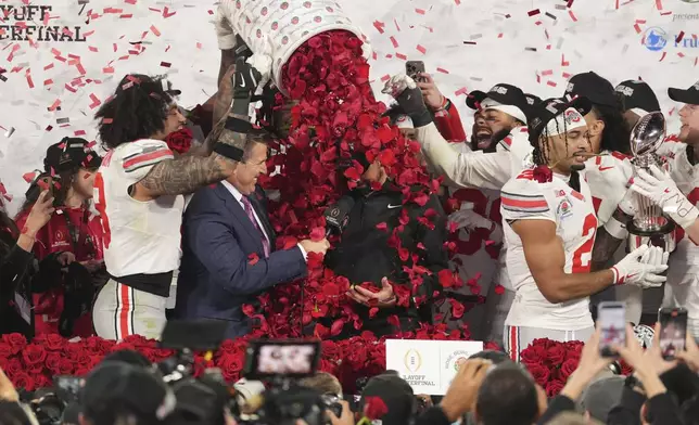 Ohio State players dunk rose petals on head coach Ryan Day after winning the quarterfinals of the Rose Bowl College Football Playoff against Oregon, Wednesday, Jan. 1, 2025, in Pasadena, Calif. (AP Photo/Mark J. Terrill)