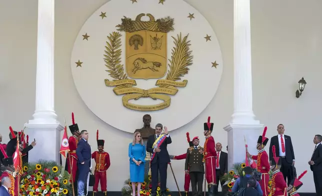 Venezuelan President Nicolas Maduro waves next to his wife Cilia Flores, after Maduro's swearing-in ceremony for a third term at the National Assembly in Caracas, Venezuela, Friday, Jan. 10, 2025. (AP Photo/Ariana Cubillos)