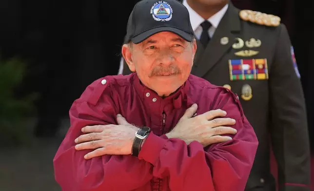 Nicaragua's President Daniel Ortega gestures to government supporters after attending the swearing-in ceremony of Venezuelan President Nicolas Maduro for a third term at the National Assembly in Caracas, Venezuela, Friday, Jan. 10, 2025. (AP Photo/Matias Delacroix)