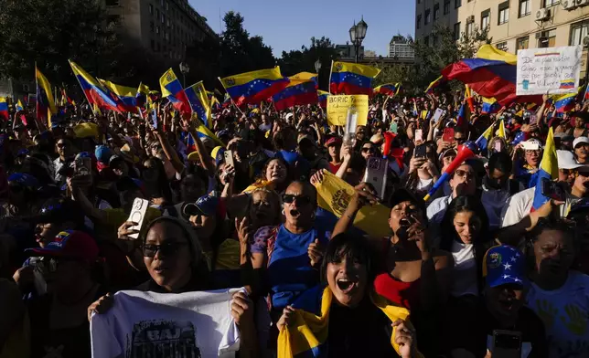 Opponents of Venezuelan President Nicolas Maduro participate in a protest the day before his inauguration for a third term, in Santiago, Chile, Thursday, Jan. 9, 2025. (AP Photo/Esteban Felix)