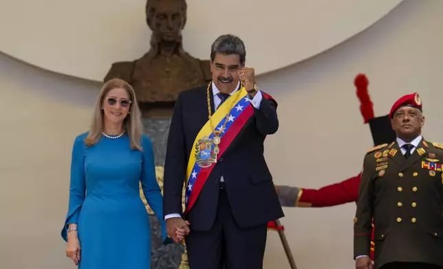 Venezuelan President Nicolas Maduro and his wife Cilia Flores stand at the National Assembly after his swearing-in ceremony for a third term in Caracas, Venezuela, Friday, Jan. 10, 2025. (AP Photo/Ariana Cubillos)