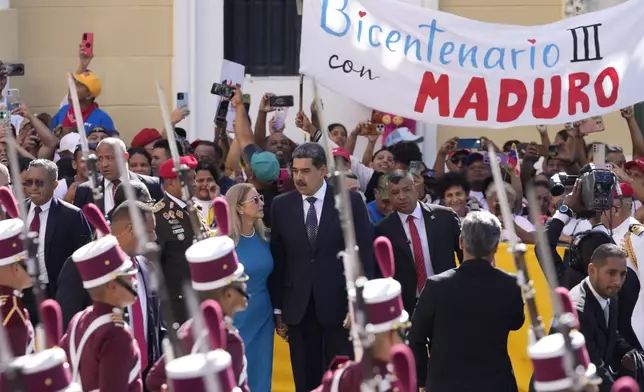 Venezuelan President Nicolas Maduro and his wife Cilia Flores arrive at the National Assembly for his swear-in ceremony for a third term in Caracas, Venezuela, Friday, Jan. 10, 2025. (AP Photo/Matias Delacroix)