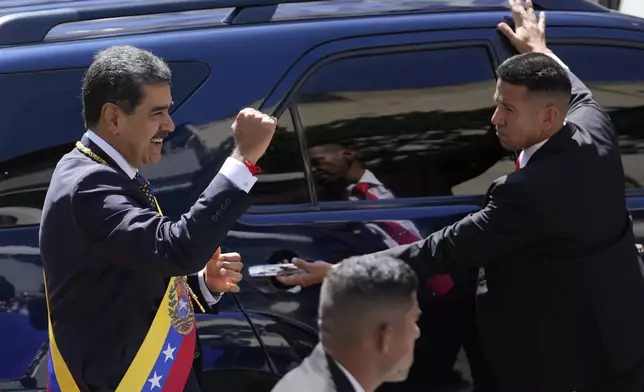 Venezuela's President Nicolas Maduro gestures to government supporters before entering a vehicle after his inauguration for a third term in Caracas, Venezuela, Friday, Jan. 10, 2025. (AP Photo/Matias Delacroix)