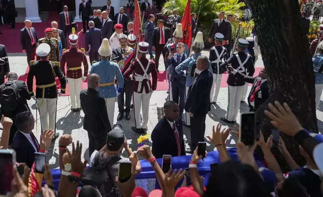 Venezuelan President Nicolas Maduro reviews the honor guard after being sworn in for a third term as government supporters gather outside the National Assembly in Caracas, Venezuela, Friday, Jan. 10, 2025. (AP Photo/Matias Delacroix)
