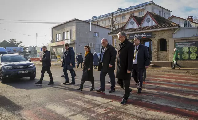 Moldova's President Maia Sandu crosses a road during a visit to areas affected by gas and electricity shortages in Varnita, Moldova, Thursday, Jan. 9, 2025. (AP Photo/Aurel Obreja)