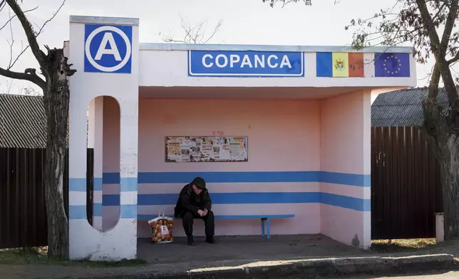 A man waits at a bus stop in Copanca, Moldova, Wednesday, Jan. 8, 2025. (AP Photo)