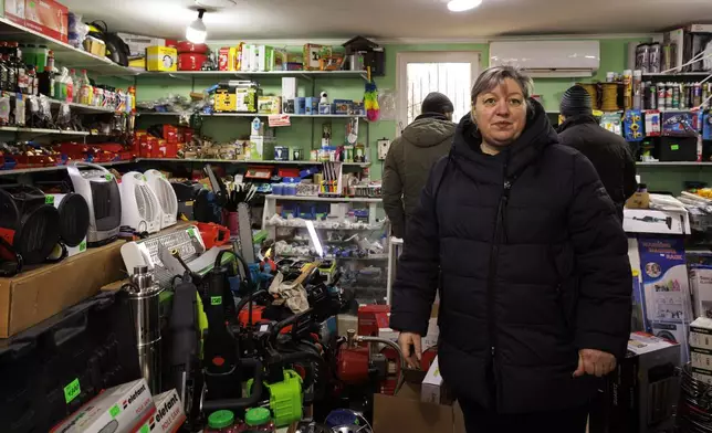 Carina Cazac, a shop owner, stands next to electrical heaters in Copanca, Moldova, Wednesday, Jan. 8, 2025. (AP Photo)