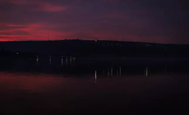 Lights are reflected in the water at dusk from the left bank of the Dniester river, the border between Moldova and Transnistria, seen from Molovata, Moldova, Wednesday, Jan. 8, 2025. (AP Photo)