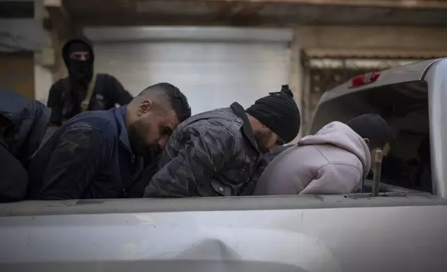 Men suspected of being part of militias or loyalist soldiers of the ousted president Bashar Assad are detained by members of the new security forces during an operation in Homs, Syria, Friday, Jan. 3, 2025. (AP Photo/Leo Correa)