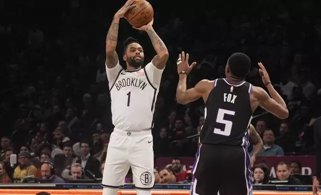 Brooklyn Nets' D'Angelo Russell (1) shoots over Sacramento Kings' De'Aaron Fox (5) during the second half of an NBA basketball game Monday, Jan. 27, 2025, in New York. (AP Photo/Frank Franklin II)