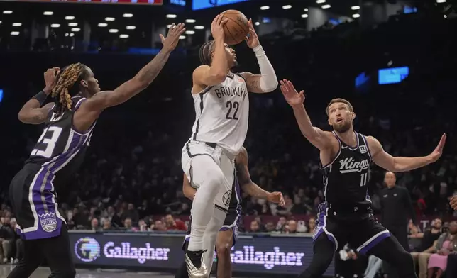 Sacramento Kings' Domantas Sabonis (11) and Keon Ellis (23) defend Brooklyn Nets' Jalen Wilson (22) during the second half of an NBA basketball game Monday, Jan. 27, 2025, in New York. (AP Photo/Frank Franklin II)