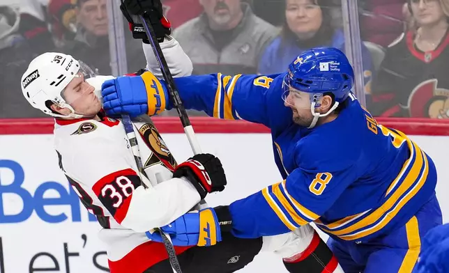 Buffalo Sabres' Dennis Gilbert (8) gives Ottawa Senators' Zack Ostapchuk (38) a shove during first period NHL hockey action in Ottawa on Thursday, Jan. 9, 2025. (Sean Kilpatrick/The Canadian Press via AP)