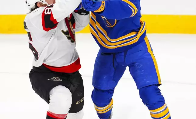 Ottawa Senators' Jake Sanderson (85) shoves Buffalo Sabres' JJ Peterka during second-period NHL hockey game action in Ottawa, Ontario, Thursday, Jan. 9, 2025. (Sean Kilpatrick/The Canadian Press via AP)