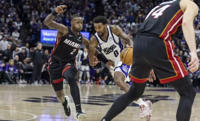 Sacramento Kings guard Malik Monk (0) drives to the basket with Miami Heat guard Terry Rozier III (2) defending during double overtime of an NBA basketball game Monday, Jan. 6, 2025, in Sacramento, Calif. The Kings win 123-118 in double overtime. (AP Photo/Sara Nevis)