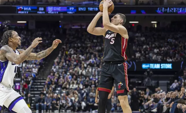 Miami Heat forward Nikola Jovic (5) attempts to shoot over Sacramento Kings forward DeMar DeRozan, left, during the first half of an NBA basketball game Monday, Jan. 6, 2025, in Sacramento, Calif. (AP Photo/Sara Nevis)