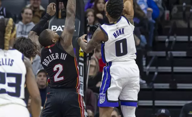 Sacramento Kings guard Malik Monk (0) goes up for a layup over Miami Heat guard Terry Rozier III (2) during the first half of an NBA basketball game Monday, Jan. 6, 2025, in Sacramento, Calif. (AP Photo/Sara Nevis)