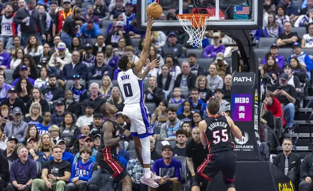 Sacramento Kings guard Malik Monk (0) makes a layup past Miami Heat guard Terry Rozier III, left, during the first half of an NBA basketball game Monday, Jan. 6, 2025, in Sacramento, Calif. (AP Photo/Sara Nevis)