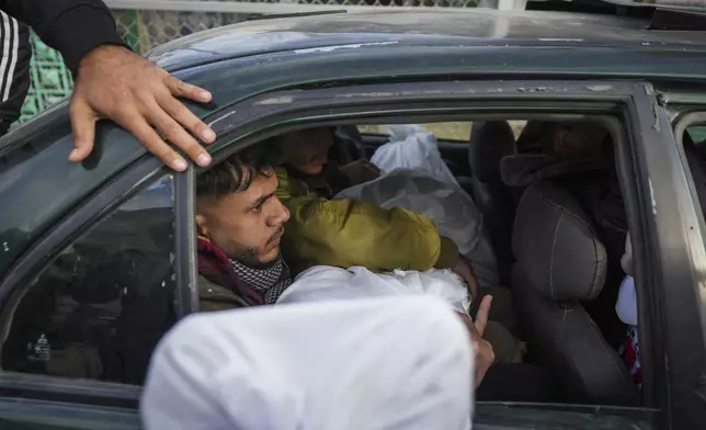 Mourners carry the bodies of their relatives killed in the Israeli bombardment of the Gaza Strip, during their funerl at Al-Aqsa Martyrs Hospital in Deir al-Balah, Sunday, Jan. 5, 2025. (AP Photo/Abdel Kareem Hana)