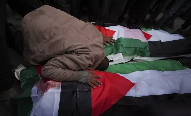 Palestinians mourn their relatives killed in the Israeli bombardment of the Gaza Strip, at Al-Aqsa Martyrs Hospital in Deir al-Balah, Sunday, Jan. 5, 2025. (AP Photo/Abdel Kareem Hana)