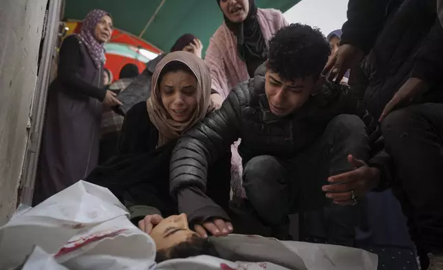 Relatives of Mohammed Al Mabhouh,15, who was killed by the Israeli bombardment of the Gaza Strip, mourn over his body at Al-Aqsa Martyrs Hospital in Deir al-Balah, Sunday, Jan. 5, 2025. (AP Photo/Abdel Kareem Hana)