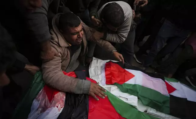 Palestinians mourn their relatives killed in the Israeli bombardment of the Gaza Strip, at Al-Aqsa Martyrs Hospital in Deir al-Balah, Sunday, Jan. 5, 2025. (AP Photo/Abdel Kareem Hana)