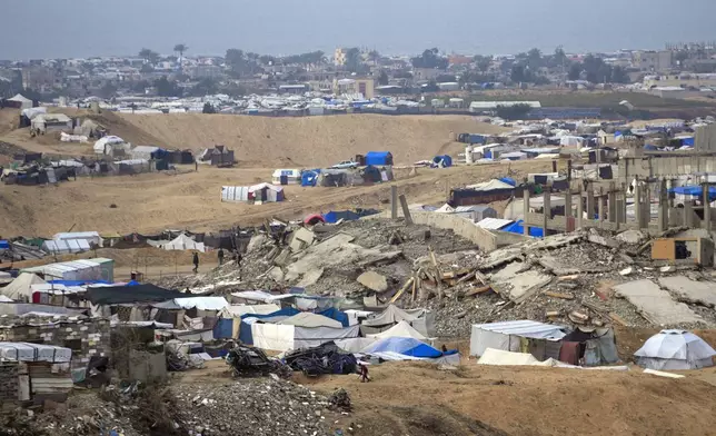 A tent camp for displaced Palestinians is set up amid destroyed buildings in the Khan Younis refugee camp, southern Gaza Strip, Saturday, Jan. 4, 2025. (AP Photo/Abdel Kareem Hana)