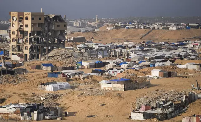 A tent camp for displaced Palestinians is set up amid destroyed buildings in the Khan Younis refugee camp, southern Gaza Strip, Saturday, Jan. 4, 2025. (AP Photo/Abdel Kareem Hana)