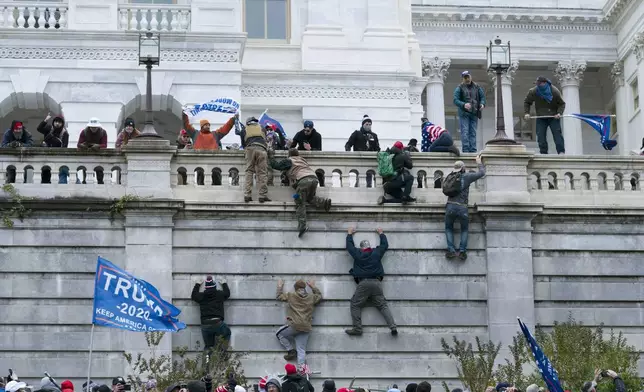 FILE - Supporters of President Donald Trump climb the west wall of the the U.S. Capitol in Washington, Jan. 6, 2021. (AP Photo/Jose Luis Magana, File)