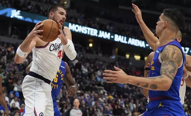 Los Angeles Clippers center Ivica Zubac, left, pulls in a rebound as Denver Nuggets forward Michael Porter Jr. defends in the first half of an NBA basketball game Wednesday, Jan. 8, 2025, in Denver. (AP Photo/David Zalubowski)