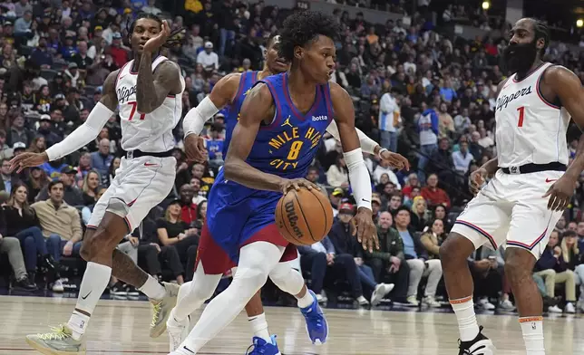 Denver Nuggets forward Peyton Watson, center, drives the baseline as Los Angeles Clippers guards Kevin Porter Jr., left, and James Harden defend in the first half of an NBA basketball game Wednesday, Jan. 8, 2025, in Denver. (AP Photo/David Zalubowski)