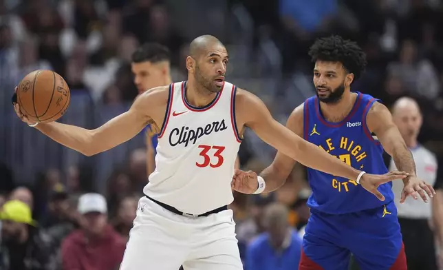 Los Angeles Clippers forward Nicolas Batum, left, looks to pass the ball as Denver Nuggets guard Jamal Murray defends in the first half of an NBA basketball game Wednesday, Jan. 8, 2025, in Denver. (AP Photo/David Zalubowski)