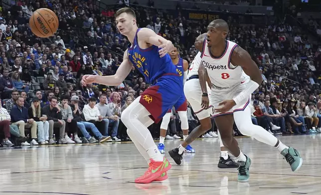 Denver Nuggets guard Christian Braun, left, and Los Angeles Clippers guard Kris Dunn pursue a loose ball in the first half of an NBA basketball game Wednesday, Jan. 8, 2025, in Denver. (AP Photo/David Zalubowski)