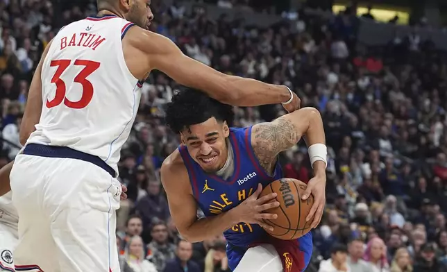 Denver Nuggets guard Julian Strawther, right, drives the lane as Los Angeles Clippers forward Nicolas Batum defends in the first half of an NBA basketball game Wednesday, Jan. 8, 2025, in Denver. (AP Photo/David Zalubowski)