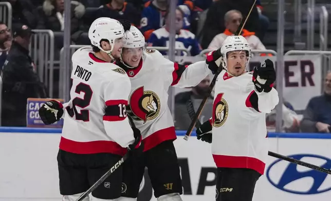 Ottawa Senators' Adam Gaudette, center, celebrates with teammates Shane Pinto (12) and Nick Cousins (21) after scoring a goal during the second period of an NHL hockey game against the New York Islanders, Tuesday, Jan. 14, 2025, in Elmont, N.Y. (AP Photo/Frank Franklin II)