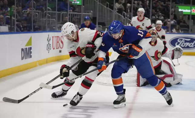 New York Islanders' Mathew Barzal (13) fights for control of the puck with Ottawa Senators' Artem Zub (2) during the second period of an NHL hockey game, Tuesday, Jan. 14, 2025, in Elmont, N.Y. (AP Photo/Frank Franklin II)