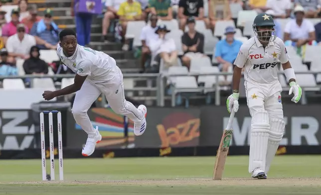 South Africa's Kwena Maphaka, left, bowls the ball while Pakistan's Babar Azam looks on during the third day of the second Test match between South Africa and Pakistan in Cape Town, South Africa, Sunday, Jan. 5, 2025. (AP Photo/Halden Krog)