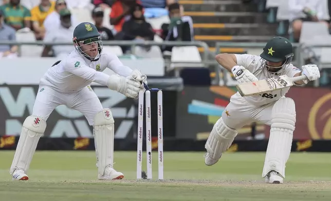 South Africa's Kyle Verreynne, left, stumps Pakistan's Salman Agha during the third day of the second Test match between South Africa and Pakistan in Cape Town, South Africa, Sunday, Jan. 5, 2025. (AP Photo/Halden Krog)