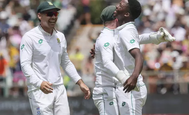 South Africa's David Bedingham, left, and Kyle Verreynne, center, congratulate Kwena Maphaka, right, on his debut test wicket during the third day of the second Test match between South Africa and Pakistan in Cape Town, South Africa, Sunday, Jan. 5, 2025. (AP Photo/Halden Krog)