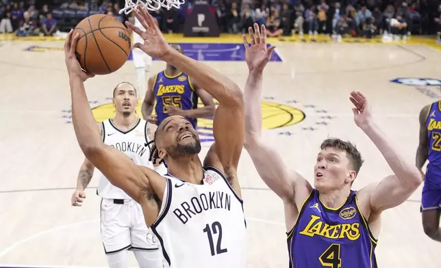 Brooklyn Nets forward Tosan Evbuomwan, left, shoots as Los Angeles Lakers guard Dalton Knecht defends during the first half of an NBA basketball game, Friday, Jan. 17, 2025, in Los Angeles. (AP Photo/Mark J. Terrill)