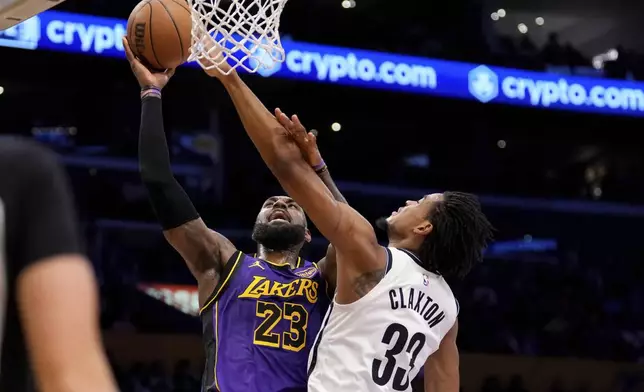 Los Angeles Lakers forward LeBron James, left, shoots as Brooklyn Nets center Nic Claxton defends during the first half of an NBA basketball game, Friday, Jan. 17, 2025, in Los Angeles. (AP Photo/Mark J. Terrill)