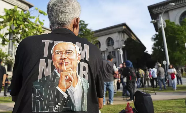 A supporter of former Prime Minister Najib Razak waits outside the Court of Appeals, in Putrajaya, Malaysia, Monday, Jan. 6, 2025, before Najib won an appeal to pursue his bid to serve his remaining corruption sentence under house arrest later Monday. (AP Photo/Vincent Thian)