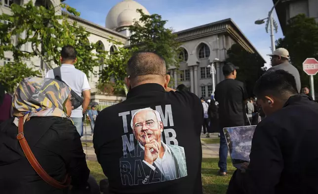 Supporters of former Prime Minister Najib Razak waits outside the Court of Appeals in Putrajaya, Malaysia, Monday, Jan. 6, 2025, before Najib won an appeal to pursue his bid to serve his remaining corruption sentence under house arrest later Monday. (AP Photo/Vincent Thian)