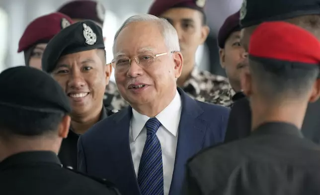 FILE - Former Malaysian Prime Minister Najib Razak arrives at the Kuala Lumpur High Court complex escorted by prison officers in Kuala Lumpur, Malaysia, Thursday, April 4, 2024. (AP Photo/Vincent Thian, File)