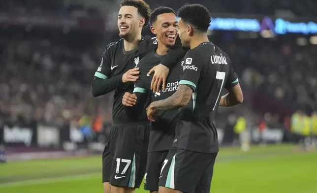 Liverpool's Trent Alexander-Arnold, center, celebrates with teammates after scoring his side's fourth goal during the English Premier League soccer match between West Ham United and Liverpool at the London Stadium in London, Sunday, Dec. 29, 2024. (AP Photo/Kirsty Wigglesworth)