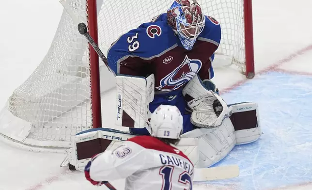 Montreal Canadiens right wing Cole Caufield, front, puts a shot on Colorado Avalanche goaltender Mackenzie Blackwood in the second period of an NHL hockey game Saturday, Jan. 4, 2025, in Denver. (AP Photo/David Zalubowski)