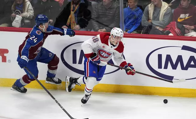 Montreal Canadiens defenseman Lane Hutson, right, collects the puck as Colorado Avalanche right wing Oskar Olausson pursues in the second period of an NHL hockey game Saturday, Jan. 4, 2025, in Denver. (AP Photo/David Zalubowski)