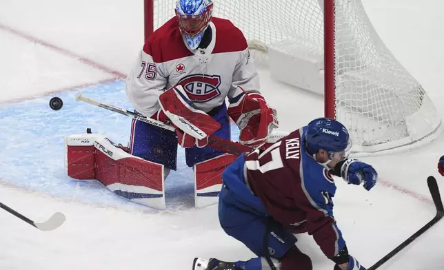 Montreal Canadiens goaltender Jakub Dobes, back, deflects a shot by Colorado Avalanche center Parker Kelly in the second period of an NHL hockey game Saturday, Jan. 4, 2025, in Denver. (AP Photo/David Zalubowski)