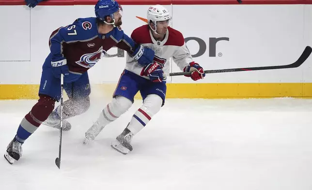 Colorado Avalanche defenseman Keaton Middleton, left, and Montreal Canadiens center Alex Newhook pursue the puck as it flies past in the second period of an NHL hockey game Saturday, Jan. 4, 2025, in Denver. (AP Photo/David Zalubowski)