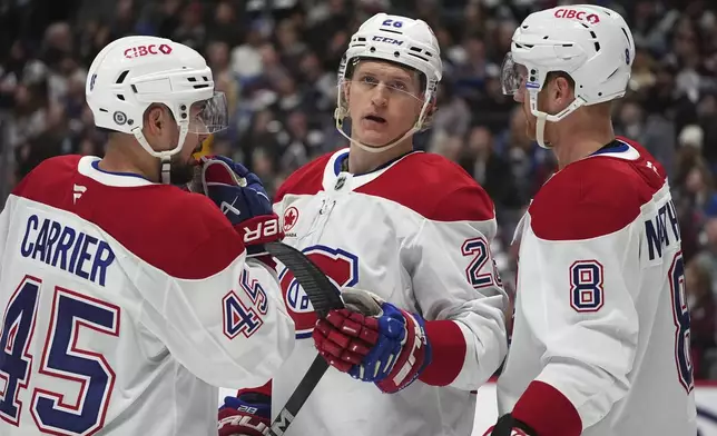 From left, Montreal Canadiens defenseman Alexandre Carrier, center Christian Dvorak and defenseman Mike Matheson confer in the first period of an NHL hockey game against the Colorado Avalanche Saturday, Jan. 4, 2025, in Denver. (AP Photo/David Zalubowski)