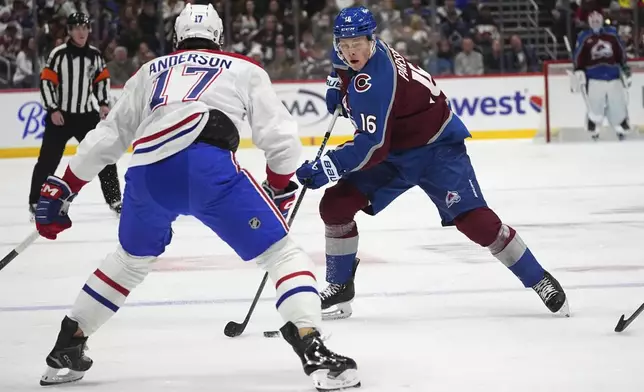 Colorado Avalanche center Juuso Parssinen, back, looks to pass the puck as Montreal Canadiens right wing Josh Anderson defends in the first period of an NHL hockey game Saturday, Jan. 4, 2025, in Denver. (AP Photo/David Zalubowski)